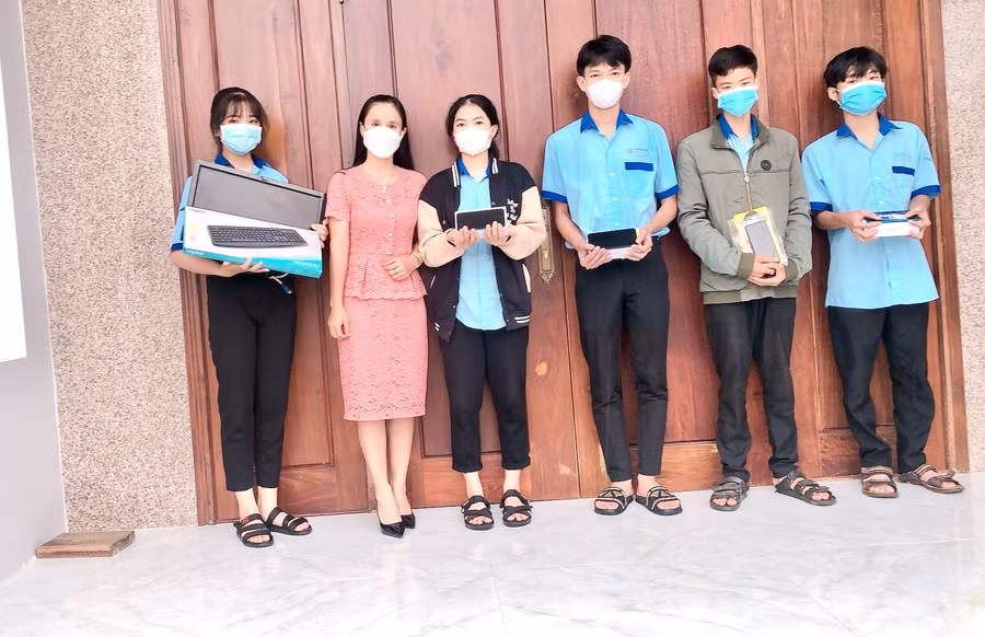 Cô Hoàng Thị Diệu Loan (thứ 2 từ trái qua) tặng máy tính và điện thoại thông minh cho các em học sinh Trường THPT Trần Quốc Tuấn (huyện Phú Thiện) học online trong mùa dịch. Ảnh: Phan Lài