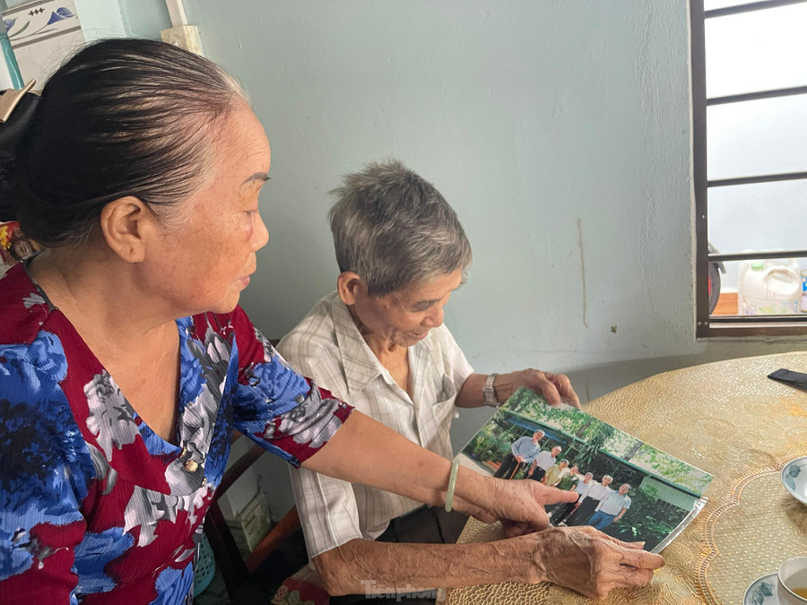 Ông Nguyễn Xuân Viên cùng vợ, bà Nguyễn Thị Tư xem lại ảnh tư liệu chụp lại lần các cựu tù Côn Đảo gặp nhau. Ảnh: Trọng Tài