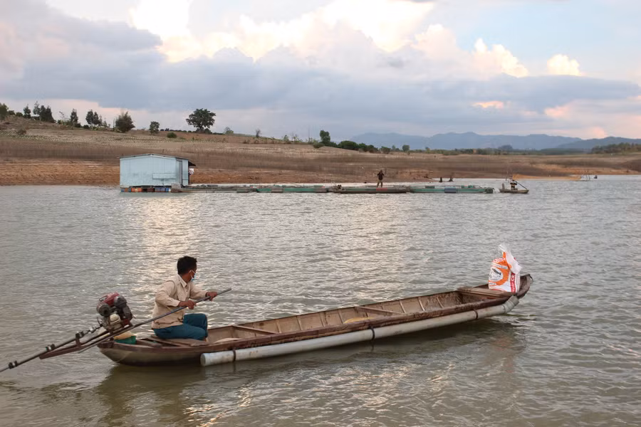 Người dân vận chuyển thức ăn ra lồng cho cá ăn. Ảnh: Nguyễn Diệp