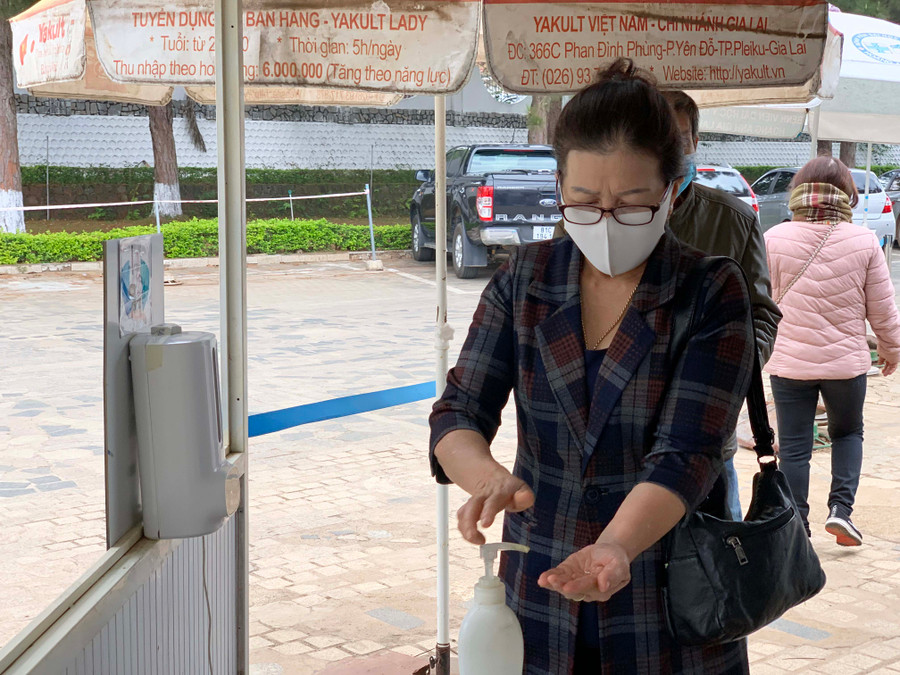 Người dân sát khuẩn tay, đo thân nhiệt tự động trước khi vào khu khám bệnh tại Bệnh viện Đai học Y dược- Hoàng Anh Gia Lai. Ảnh: Như Nguyện