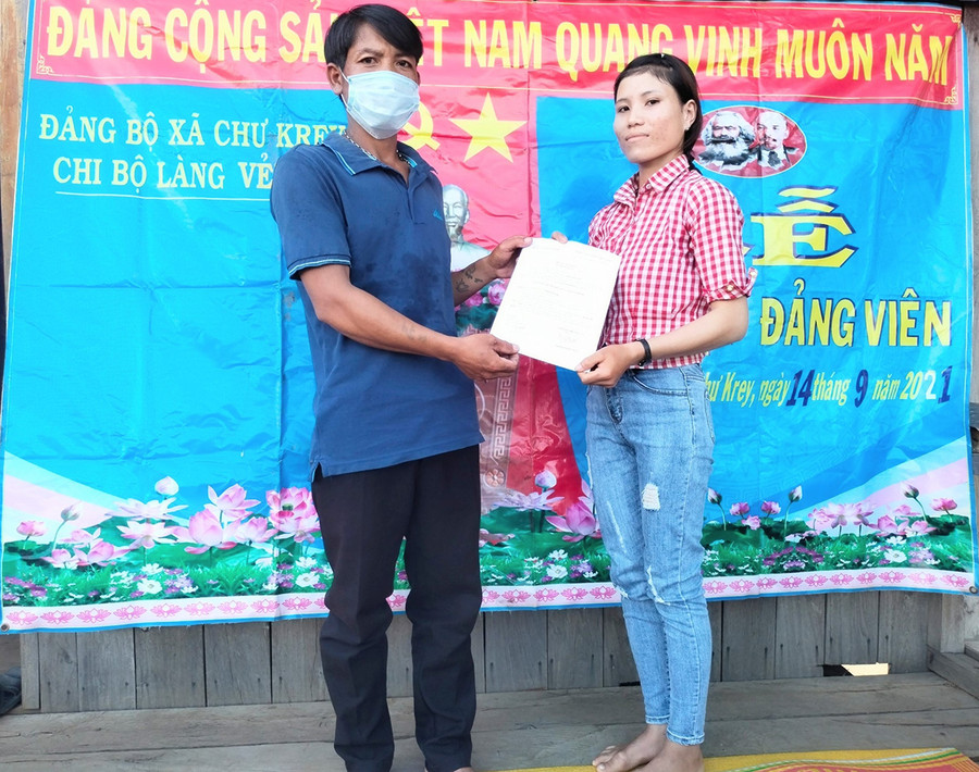  Đại diện Chi bộ làng Vẻh trao quyết định kết nạp đảng viên cho chị Bden. Ảnh: Anh Huy