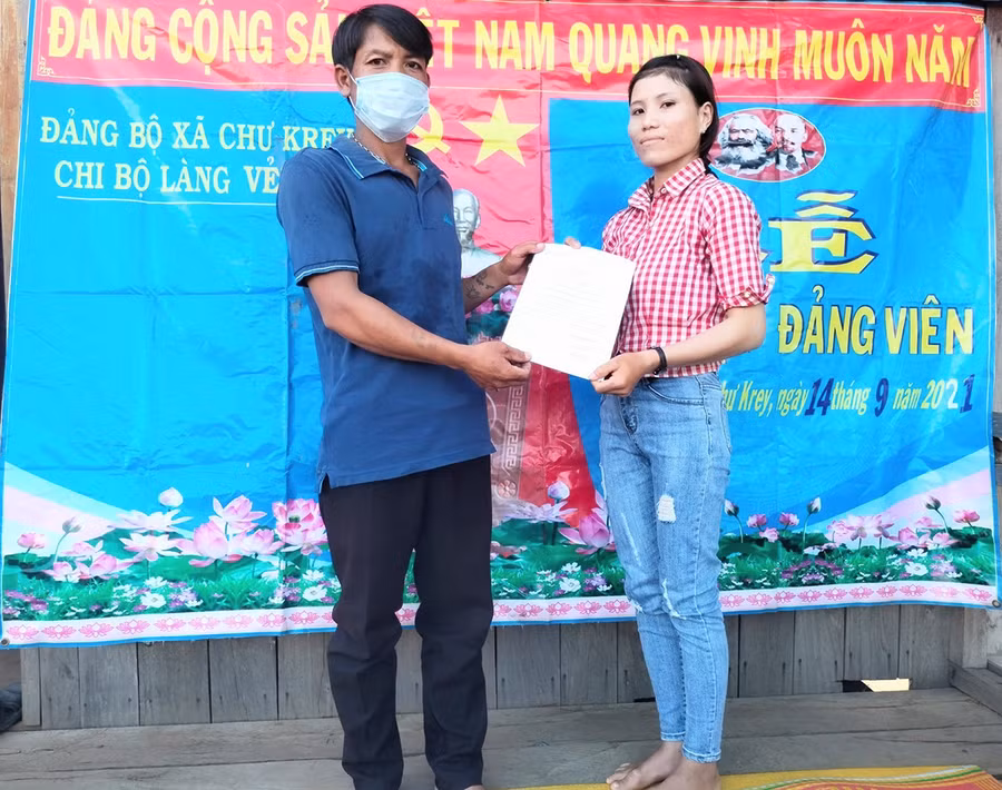  Đại diện Chi bộ làng Vẻh trao quyết định kết nạp đảng viên cho chị Bden. Ảnh: Anh Huy