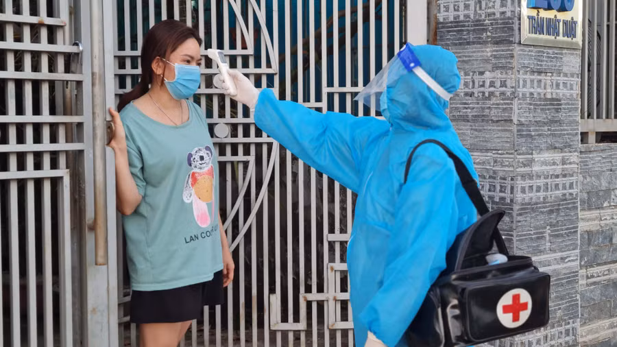 Nhân viên y tế kiểm tra thân nhiệt cho trường hợp F0 đang cách ly, điều trị tại nhà ở thôn 2 (xã Diên Phú, TP. Pleiku). Ảnh: Bá Bính