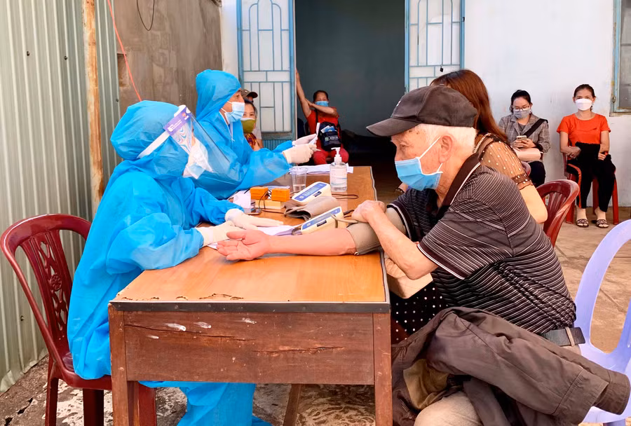 Nhân viên y tế khám sàng lọc sức khỏe trước khi tiêm vắc xin phòng Covid-19 cho người dân trên địa bàn TP. Pleiku. Ảnh: Như Nguyện