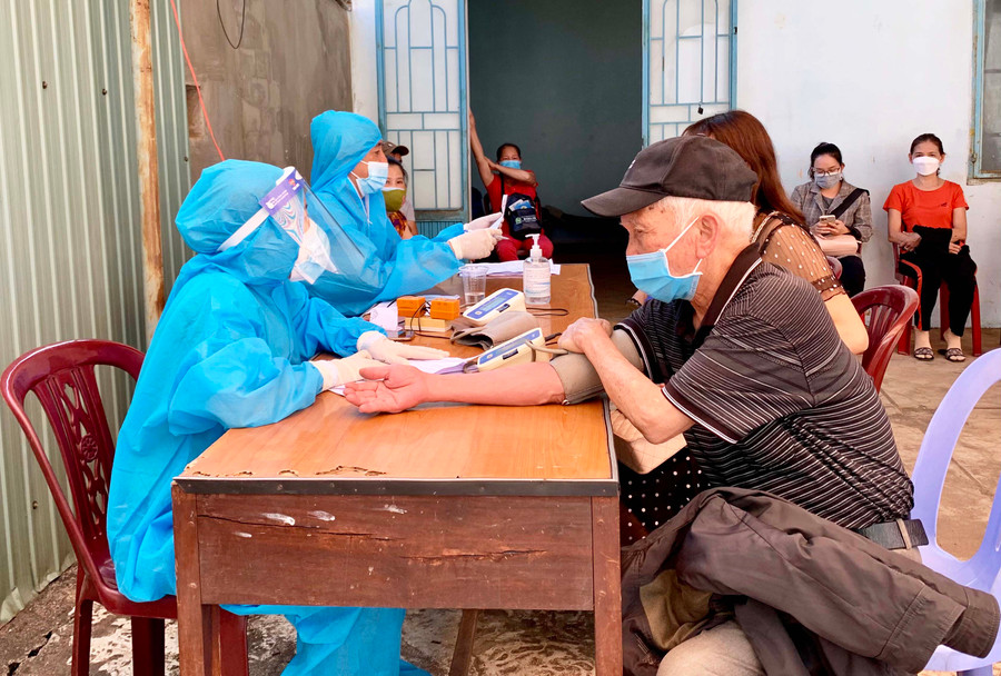 Nhân viên y tế khám sàng lọc sức khỏe trước khi tiêm vắc xin phòng Covid-19 cho người dân trên địa bàn TP. Pleiku. Ảnh: Như Nguyện