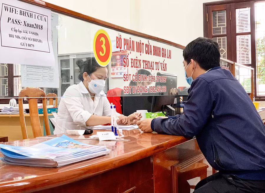  Cán bộ BHXH tỉnh hướng dẫn người dân các thủ tục liên quan chính sách BHXH. Ảnh: Như Nguyện