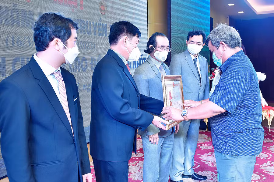 Thừa ủy quyền của Chủ tịch nước, Ủy viên Ban Thường vụ Tỉnh ủy, Chủ tịch Ủy ban MTTQ Việt Nam tỉnh Hồ Văn Điềm (ở giữa) trao Huân chương Lao động hạng nhất cho tập thể Báo Gia Lai. Ảnh: Đức Thụy