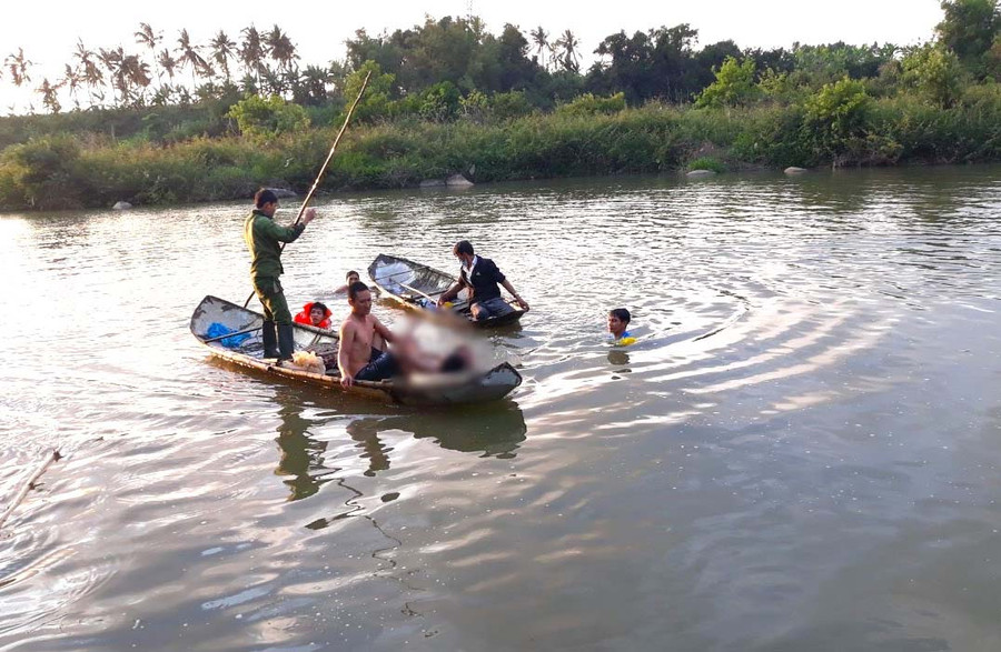 Lực lượng Công an cùng người dân đưa thi thể 2 học sinh đuối nước lên bờ. Ảnh: An Phát