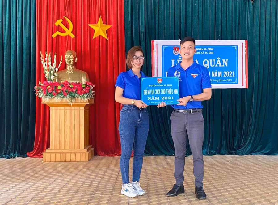 Anh Nguyễn Như Quang (bìa phải)-Ủy viên Ban Thường vụ Huyện Đoàn, Phó Chủ tịch Hội LHTN Việt Nam huyện Ia Grai tặng bảng tượng trưng điểm vui chơi cho Đoàn xã Ia Sao (huyện Ia Grai). Ảnh chụp tháng 2-2021 