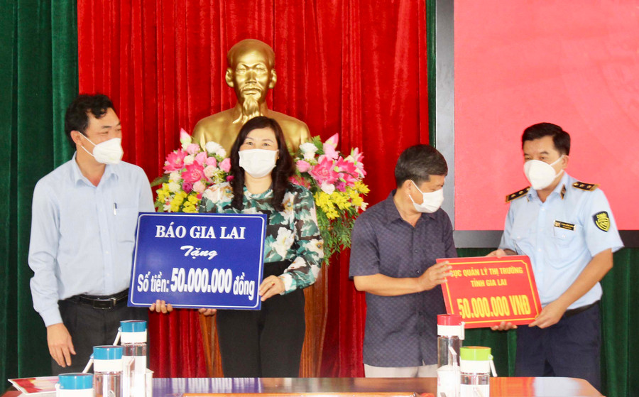 Báo Gia Lai và Cục Quản lý Thị trường tỉnh trao tiền tài trợ cho chương trình “Mái ấm biên cương” tại huyện Ia Grai. Ảnh: Phan Lài