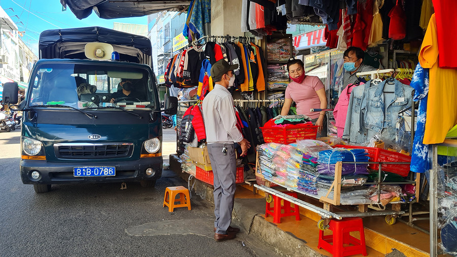  Lực lượng chức năng TP. PLeiku nhắc nhở các hộ kinh doanh lấn chiếm lòng đường làm nơi kinh doanh tại khu vực Trung tâm thương mại Pleiku. Ảnh: Bá Bính
