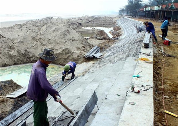 Công nhân đang gấp rút thi công dự án đường dạo bộ và bờ kè dài hơn 1km tại thị xã Cửa Lò để phục vụ mùa du lịch 2022. Ảnh: Tá Chuyên/TTXVN