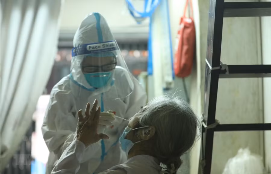 Nhân viên y tế lấy mẫu xét nghiệm cho người dân. Ảnh: Minh Quyết/TTXVN