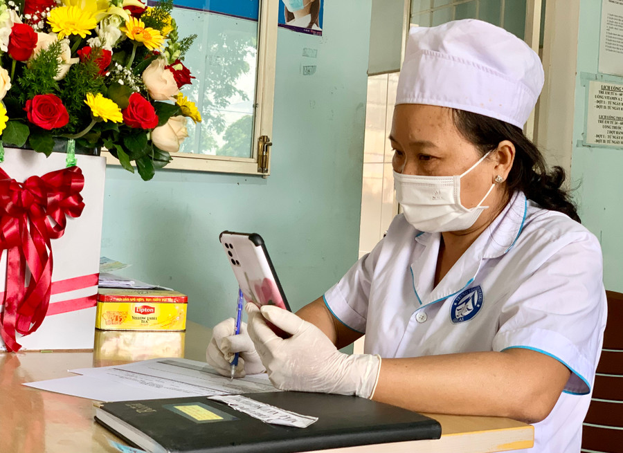 Y sĩ Lê Thị Thanh Thủy-Trạm Y tế phường Phù Đổng (TP. Pleiku) tư vấn sức khỏe qua điện thoại cho F0 cách ly, điều trị tại nhà trên địa bàn phường. Ảnh: Như Nguyện