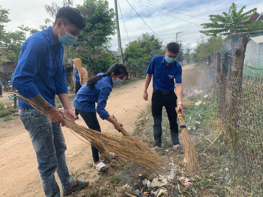 Anh Lê Quang Hiển (bìa phải, Bí thư Chi đoàn thôn Điểm 9, xã Ia Hiao, huyện Phú Thiện) cùng đoàn viên, thanh niên dọn vệ sinh đường làng, ngõ xóm. Ảnh: Vũ Chi