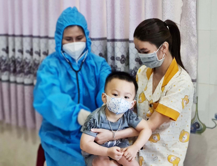 Nhân viên y tế phường Diên Hồng (TP. Pleiku) kiểm tra sức khỏe cho trẻ em thực hiện điều trị Covid-19 tại nhà. Ảnh: Bá Bính