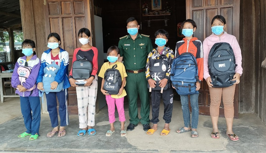 Đại úy Đinh ƠRing tặng quà cho các em thiếu nhi có hoàn cảnh khó khăn. Ảnh: Hà Đức Thành