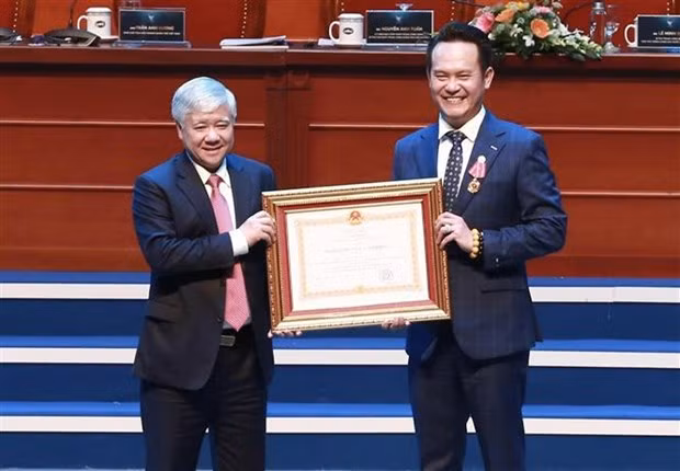 Chủ tịch Ủy ban Trung ương Mặt trận Tổ quốc Việt Nam Đỗ Văn Chiến trao Huân chương Lao động cho Phó Chủ tịch Hội Liên hiệp thanh niên Việt Nam, Chủ tịch Hội Doanh nhân trẻ Việt Nam Đặng Hồng Anh. (Ảnh: Minh Đức/TTXVN)