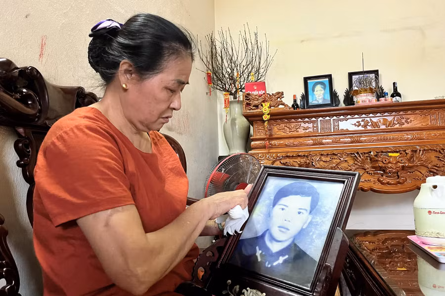 Bà Nguyễn Thị Tần bên di ảnh của người chồng - thuyền trưởng Anh hùng Vũ Phi Trừ