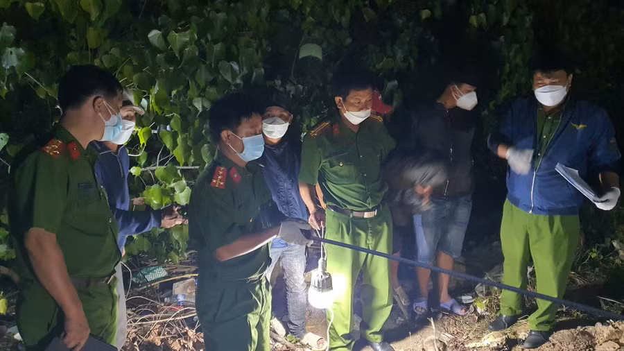 Công an khám hiện trường chôn xác nạn nhân tại nghĩa địa. Ảnh: Trị Bình