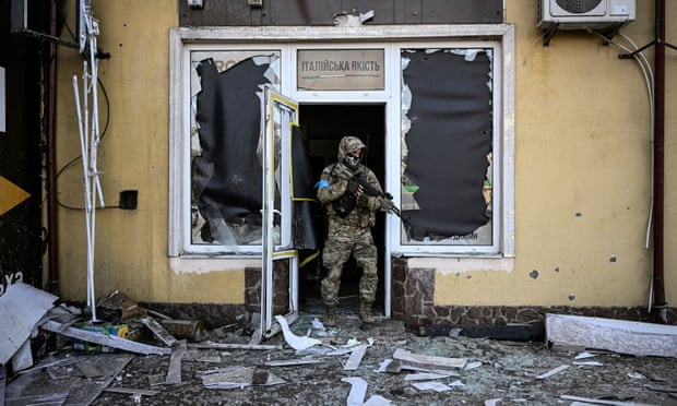 Một binh sĩ Ukraine rời khỏi một tòa nhà bị hư hại do pháo kích ở Kiev vào ngày 12/3. Ảnh: Aris Messinis/Getty Images