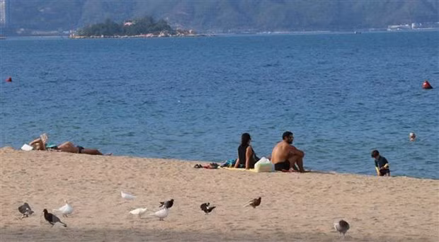 Du khách nước ngoài tắm nắng trên bãi biển Nha Trang. Ảnh: Tiên Minh/TTXVN