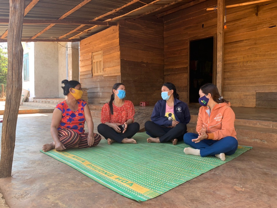 Chị Lin (thứ 2 từ phải qua) ngồi trò chuyện vui vẻ với mọi người trong sân nhà sạch sẽ của mình