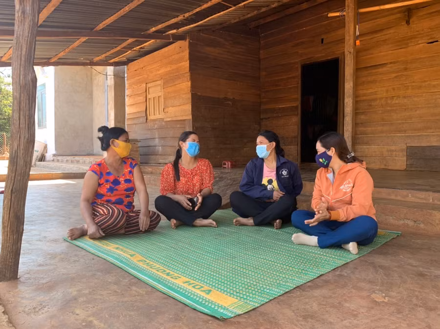 Chị Lin (thứ 2 từ phải qua) ngồi trò chuyện vui vẻ với mọi người trong sân nhà sạch sẽ của mình