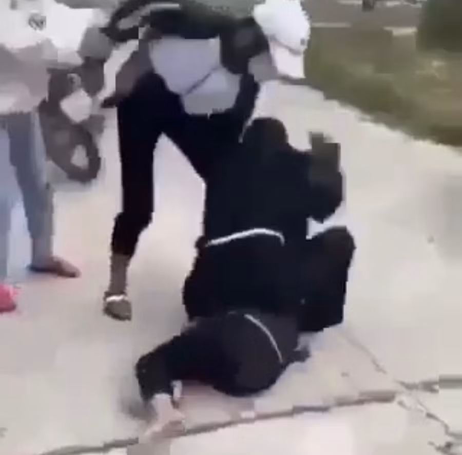 Mặc dù nhiều người ngăn cản nhưng nữ sinh vẫn bị hành hung liên tục. Ảnh cắt từ clip