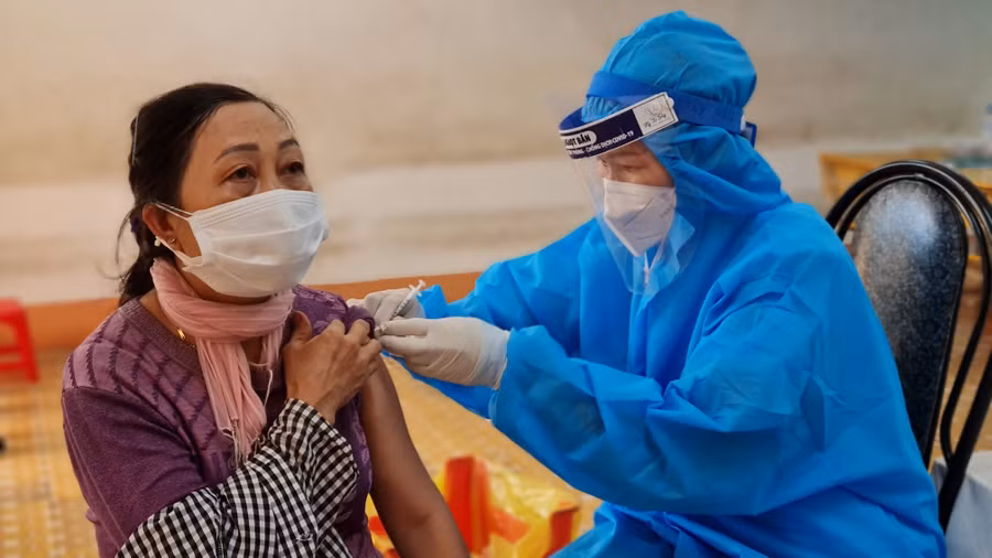 Nhân viên y tế tiêm vắc xin phòng Covid-19 cho người dân tại điểm tiêm Trường Tiểu học Chu Văn An (phường Tây Sơn, TP. Pleiku). Ảnh: Bá Bính