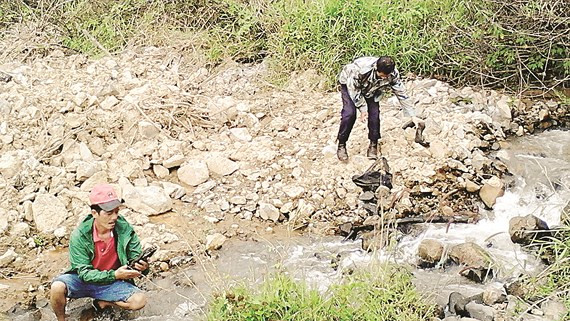 Nghệ nhân Nguyễn Phi Hải (áo đỏ) trong chuyến “săn đá” tại bãi đá lộ thiên dưới chân núi Voi.
