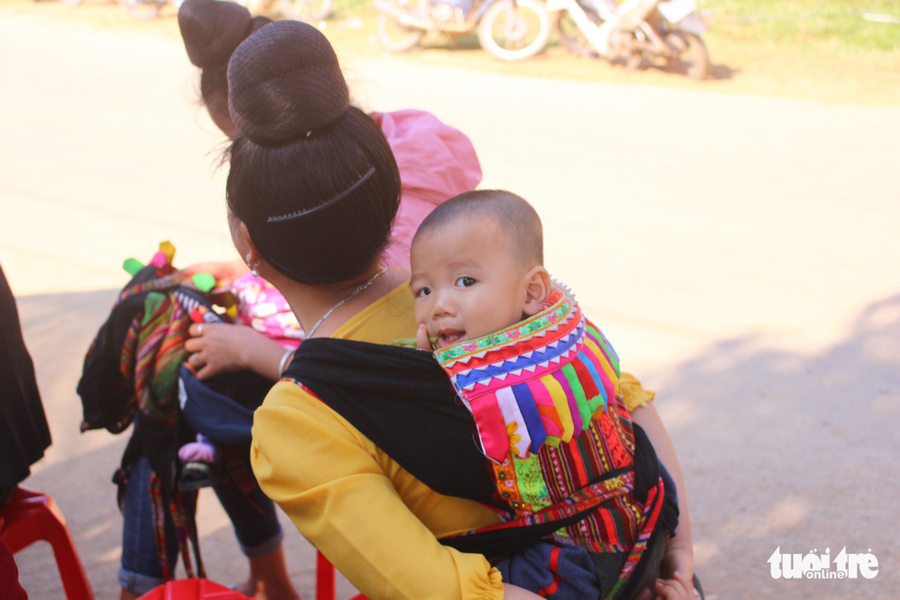  Em bé dân tộc Thái thích thú được mẹ địu trên lưng