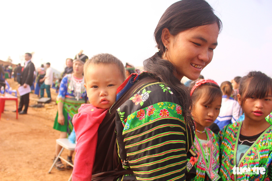  Chị Thào Thị Sai (20 tuổi) địu con gái Lò Thị Quân (1 tuổi) đi vui hội