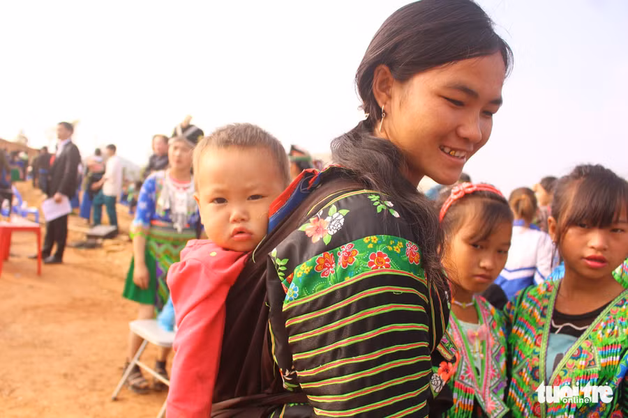  Chị Thào Thị Sai (20 tuổi) địu con gái Lò Thị Quân (1 tuổi) đi vui hội