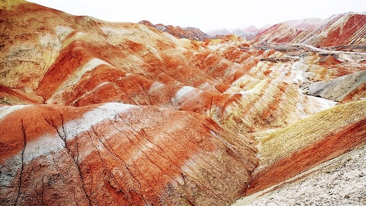  Hình thái đất Danxia được cho là được tích tụ từ Kỷ Creta, nhìn từ xa như chiếc giường màu đỏ, đặc trưng bởi những vách đá ngắn dốc.