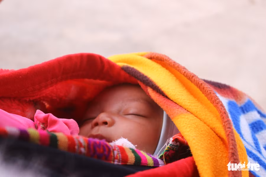  Một em bé say giấc nồng trên lưng mẹ