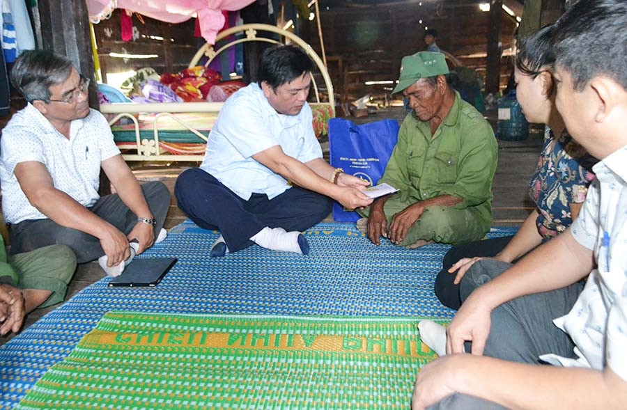 Phó Chủ tịch UBND tỉnh Kpa Thuyên thay mặt lãnh đạo Tỉnh ủy, HĐND, UBND tỉnh tặng quà cho ông Đinh Nu Na (xã Pơ Tó, huyện Ia Pa). Ảnh: Lê Nam