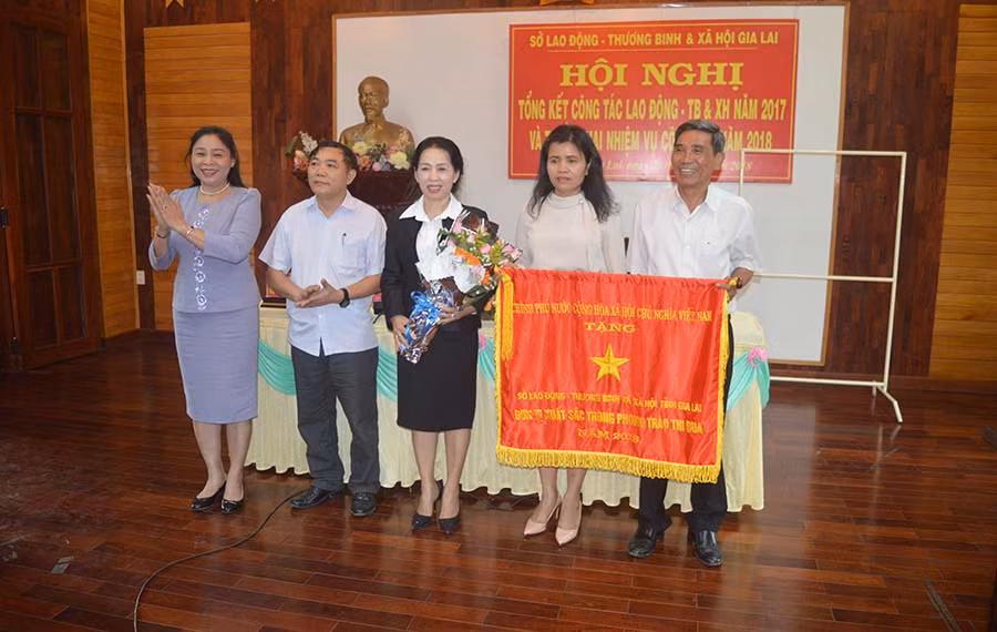  Đồng chí Huỳnh Nữ Thu Hà-Ủy viên Ban Thường vụ Tỉnh ủy, Phó Chủ tịch UBND tỉnh trao cờ thi đua cho ngành Lao động-Thương binh và Xã hội. Ảnh: Đ.Y