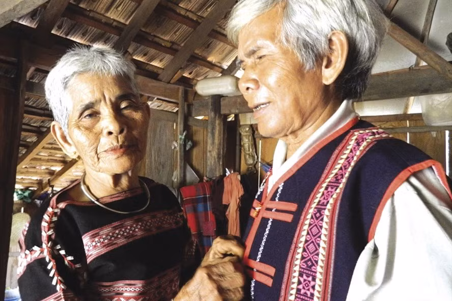 Bà Linh cài lại cúc áo cho chồng.