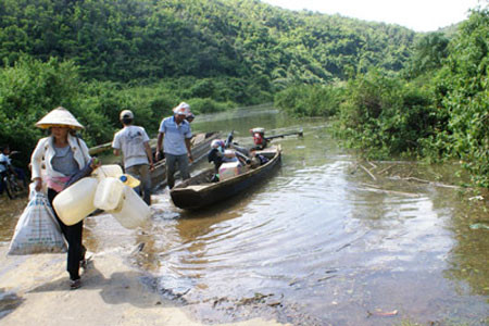 Quốc lộ 28 bị ngập, người dân phải đi làm rẫy bằng xuồng.