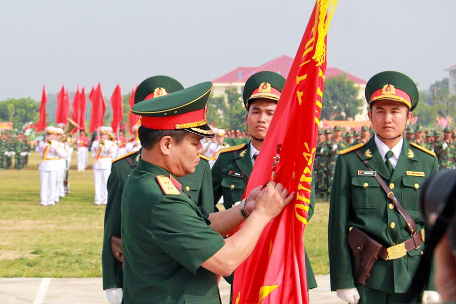 Trung tướng Lê Chiêm-Thứ trưởng Bộ Quốc phòng gắn Huân chương Bảo vệ Tổ quốc hạng nhì lên cờ truyền thống của Sư đoàn Bộ binh 2. Ảnh: Hồng Thi