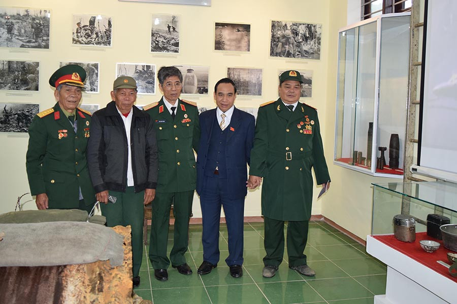 Những cựu chiến binh từng làm nên chiến thắng huyền thoại ở đồi A Bia chụp ảnh lưu niệm tại nhà trưng bày các hiện vật, kỷ vật về Khu Di tích Lịch sử quốc gia đồi A Bia. Ảnh: Bùi Oanh