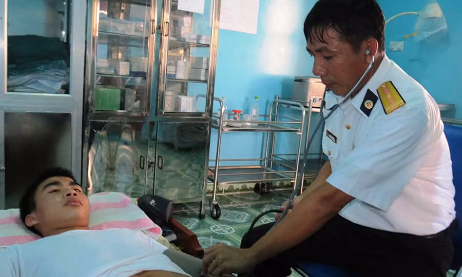 Bác sĩ Bùi Đình Dong ở nhà giàn DK1/2 khám bệnh cho ngư dân bị bí tiểu. Ảnh: Mai Thắng