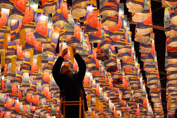  Một du khách treo tờ giấy ghi điều ước lên chiếc đèn lồng ở Tây An, tỉnh Thiểm Tây, Trung Quốc, ngày 8-2