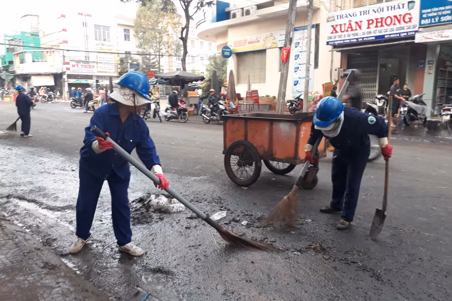 Công nhân Công ty Công trình Đô thị Pleiku đang hối hả dọn rác. Ảnh: N.T