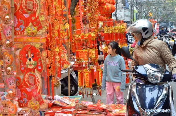  Khách hàng đang chọn đồ trang trí Tết, vài phong bao lì xì tại một gian hàng ở Hà Nội.