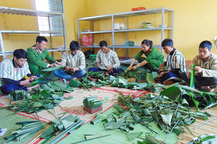 Cán bộ quản giáo Trại tạm giam T20 cùng phạm nhân gói bánh chưng đón Tết. Ảnh: Lê Anh Cán bộ quản giáo Trại tạm giam T20 cùng phạm nhân gói bánh chưng đón Tết. Ảnh: Lê Anh