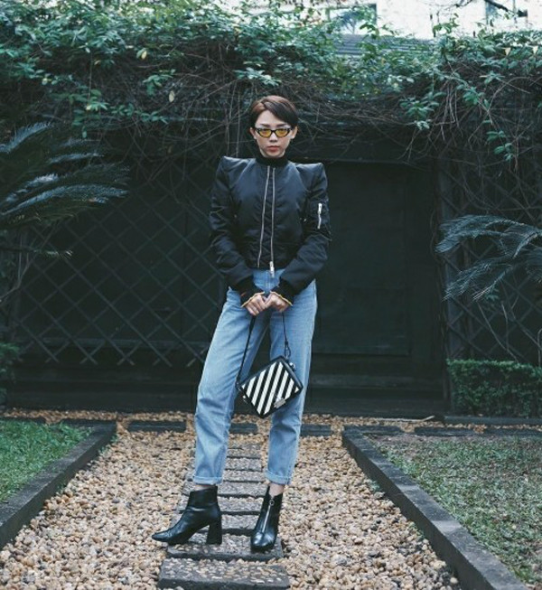 Quần jean xắn gấu, áo bomber phom dáng độc đáo được Tóc Tiên phối hợp cùng nhau. Phụ kiện đi kèm là bốt mũi nhọn và túi kẻ sọc trắng đen thời thượng.