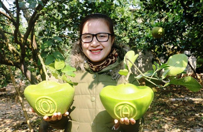 Chị Trang, một khách mua thích thú khi chọn được cặp bưởi ưng ý.