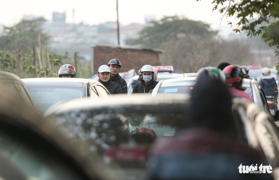 Càng về chiều, lượng người đổ ra khu vườn đào Nhật Tân, bãi đá sông Hồng ngày càng đông khiến các tuyến đường dẫn nhiều lúc ùn tắc